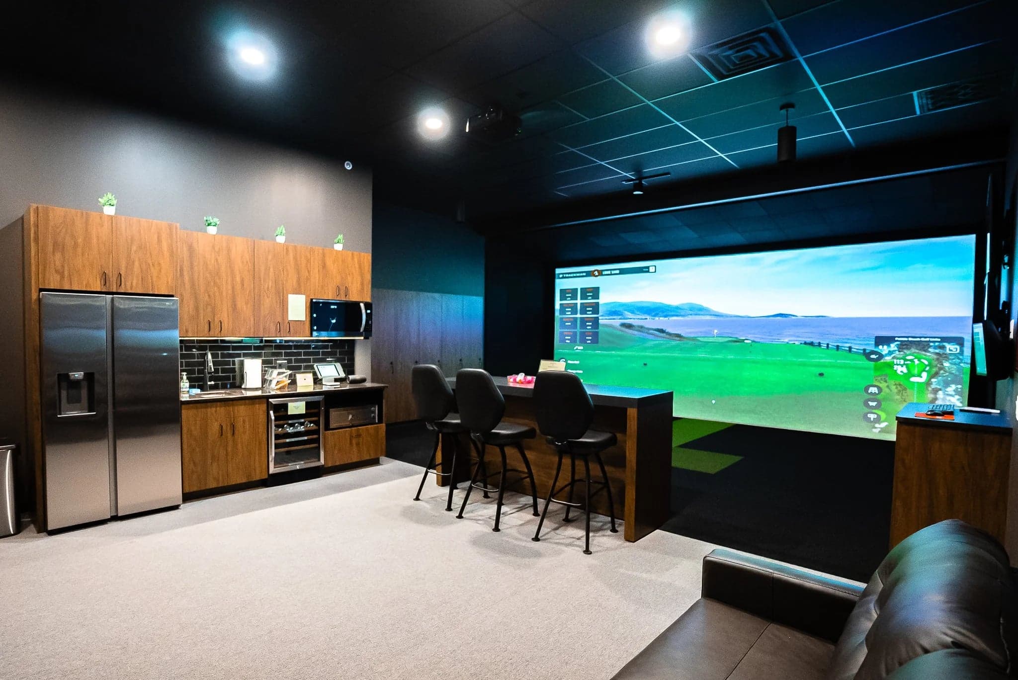 bogibox Golf Woodbury — Private clubhouse: full kitchen with stainless fridge and timber cabinetry along one wall,
