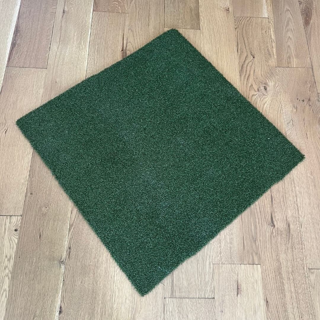 MoneyPutt putting turf laid on a pale wood floor, shot from above at an angle